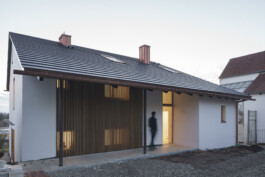 Außenansicht des 50er JAhrehauses nach der Sanierung und dem Umbau mit vertikaler Lattung