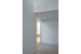 Einblick in das neu sanierte Bad mit HOlzboden und rundem Spiegel