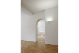 Wiederhergestellter historischer Durchgang mit Rundbogen, Fischgrätparkett, hohen Räumen und Sichtachse