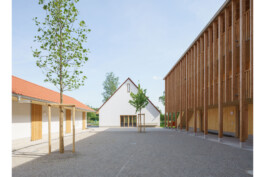 Gigebelansicht des Gemeinschaftshauses, links das Nebengebäude, rechts eins der Wohnhäuser, BAumpflanzungen im HOf