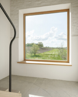 Ausblick aus dem sanierten und umgebauten Bauernhaus vom Treppenabsatz auf die freie Landschaft 