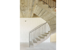 Halbgewendelte treppe Ortbeton als Sichtbeton mit Holzstruktur, Geländer Rohstahl senkrechte stäbe, HAndlauf Rundrohr