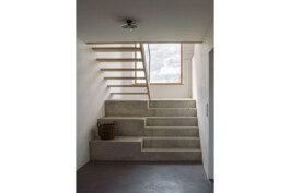 Blick vom Flur im erdgeschoss auf den ersten Treppenabsatz mit Ausblick, erster treppenlauf aus Ortbeton, davor Sichtestrich