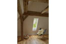 Kinderzimmer mit Holzboden,rahmenlosem Dachflächenfenster, historischer Sichtdachstuhl
