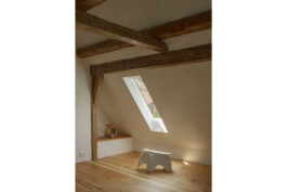 Kinderzimmer mit Holzboden,rahmenlosem Dachflächenfenster, historischer Sichtdachstuhl, Sitznische