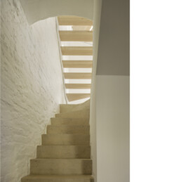 Treppenhaus Sichtbtontreppe unter Holz-Stahltreppe flankiert von historischem, geschlämmtem Sichtmauerwerk 