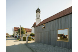 Ansicht dvon nOrdenentlang der Dorfstraße mit Fassade im Vordergrund und Kirche im Straßenverlauf