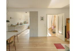 Blick vom Wohnzimmer in die Küche und den Flur mit Treppe